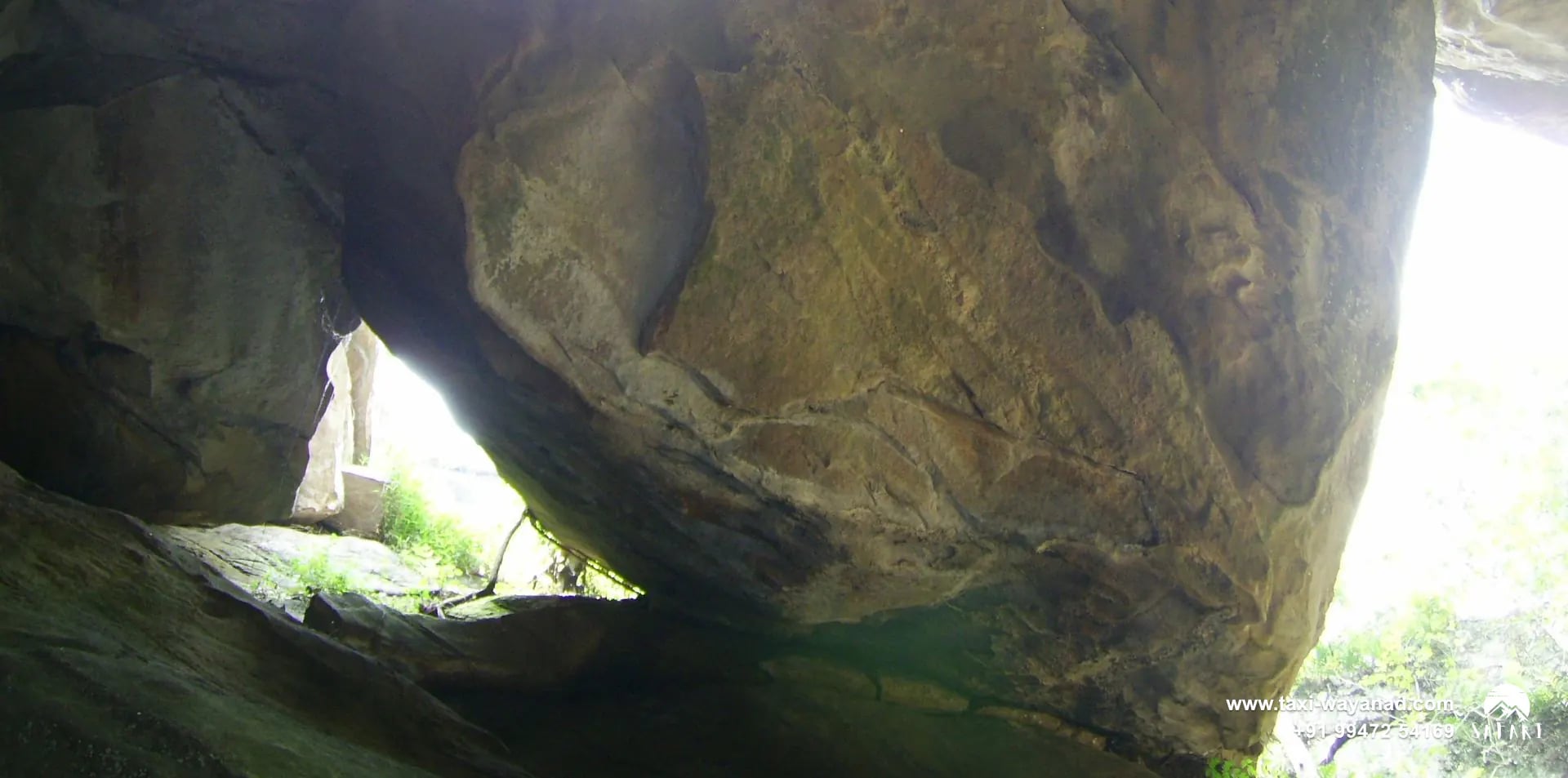 Giant boulder wedged between rock walls inside Edakkal Caves, Wayanad