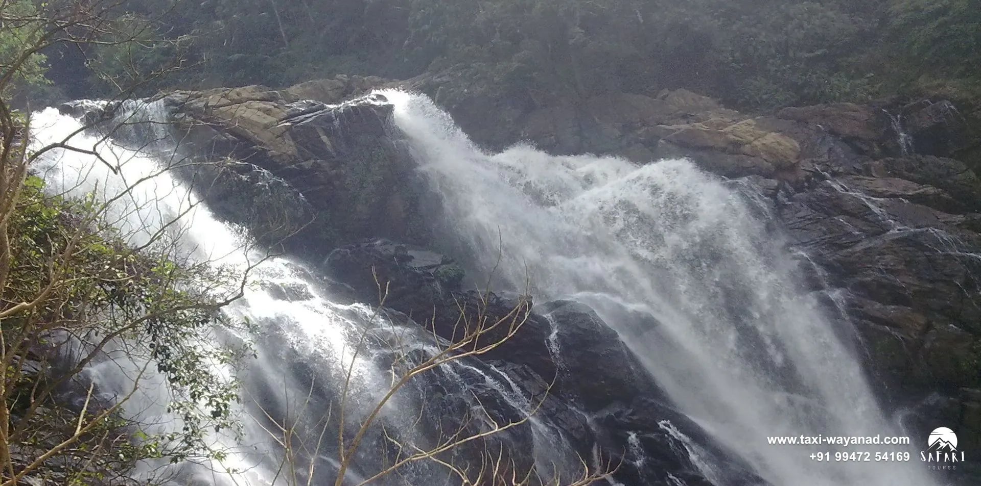 Meenmutty Waterfalls pouring in broad white streams over dark rock, Wayanad