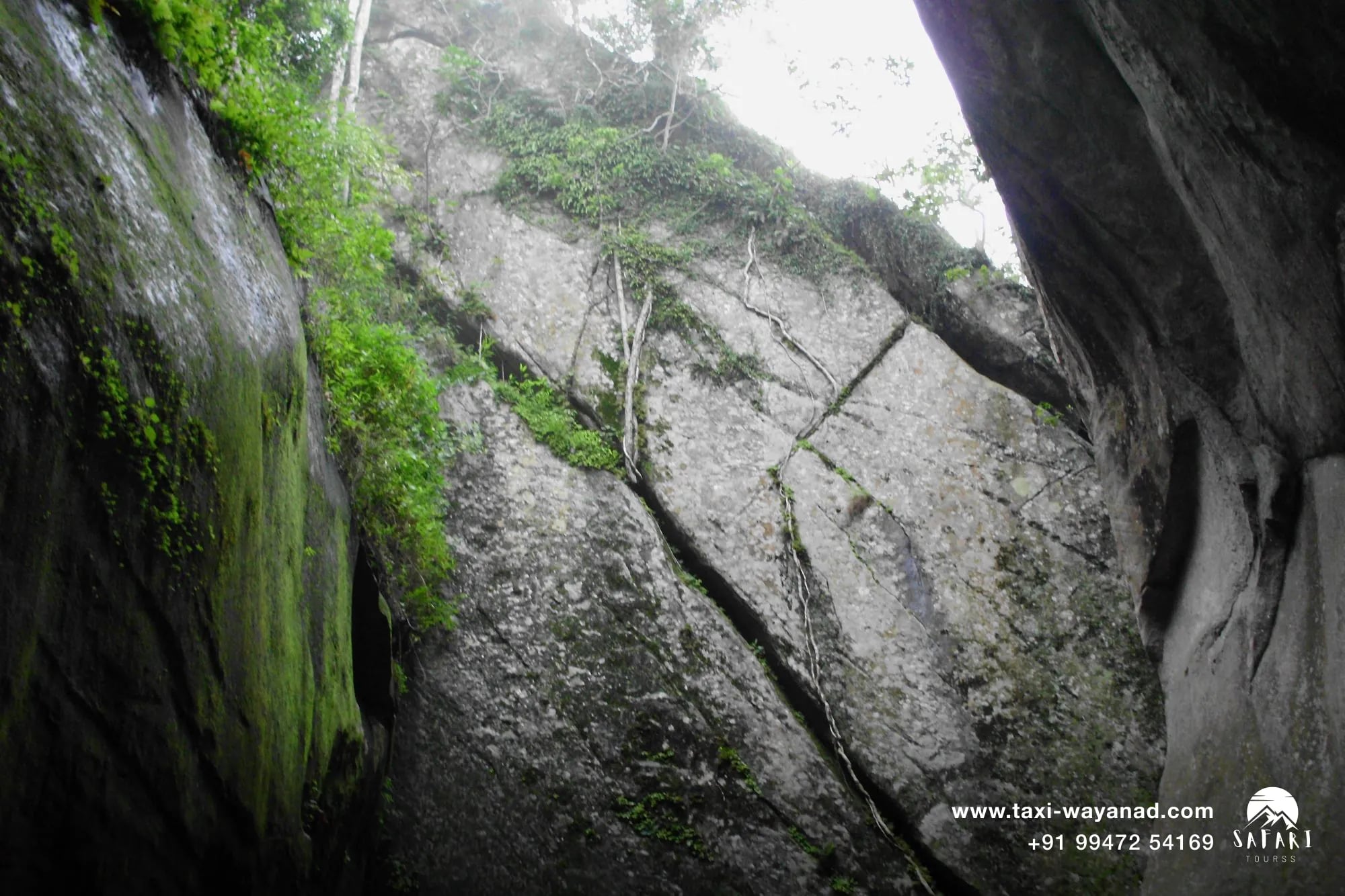 Steep rock fissure climb at Edakkal Caves, a key stop on a Wayanad one-day trip