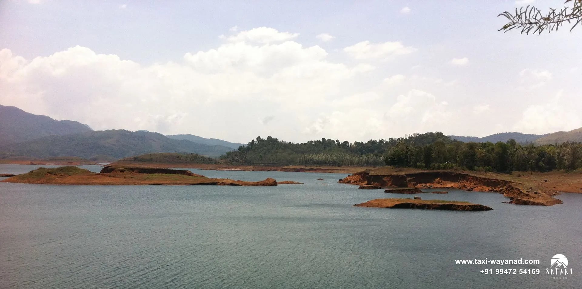 Boats on the shore and islands dotting the reservoir at Banasura Sagar Dam, Wayanad