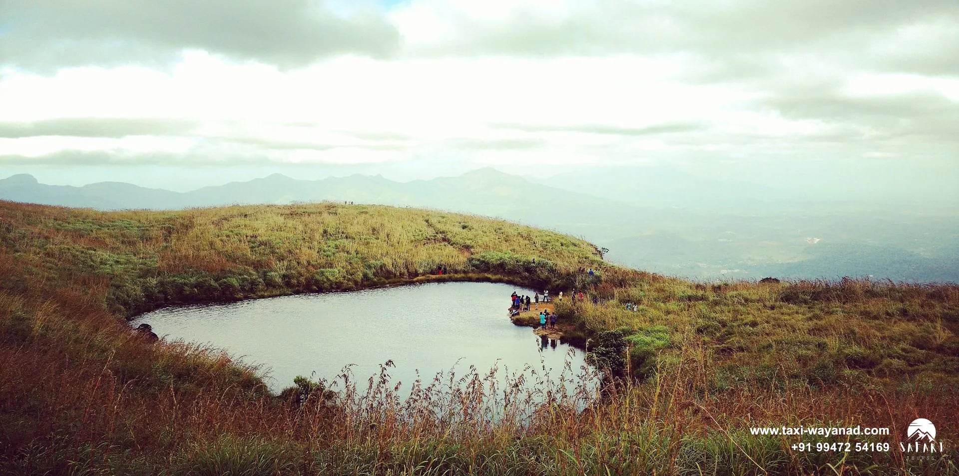 Heart-shaped lake ringed by golden grass on the Chembra Peak trek, Wayanad