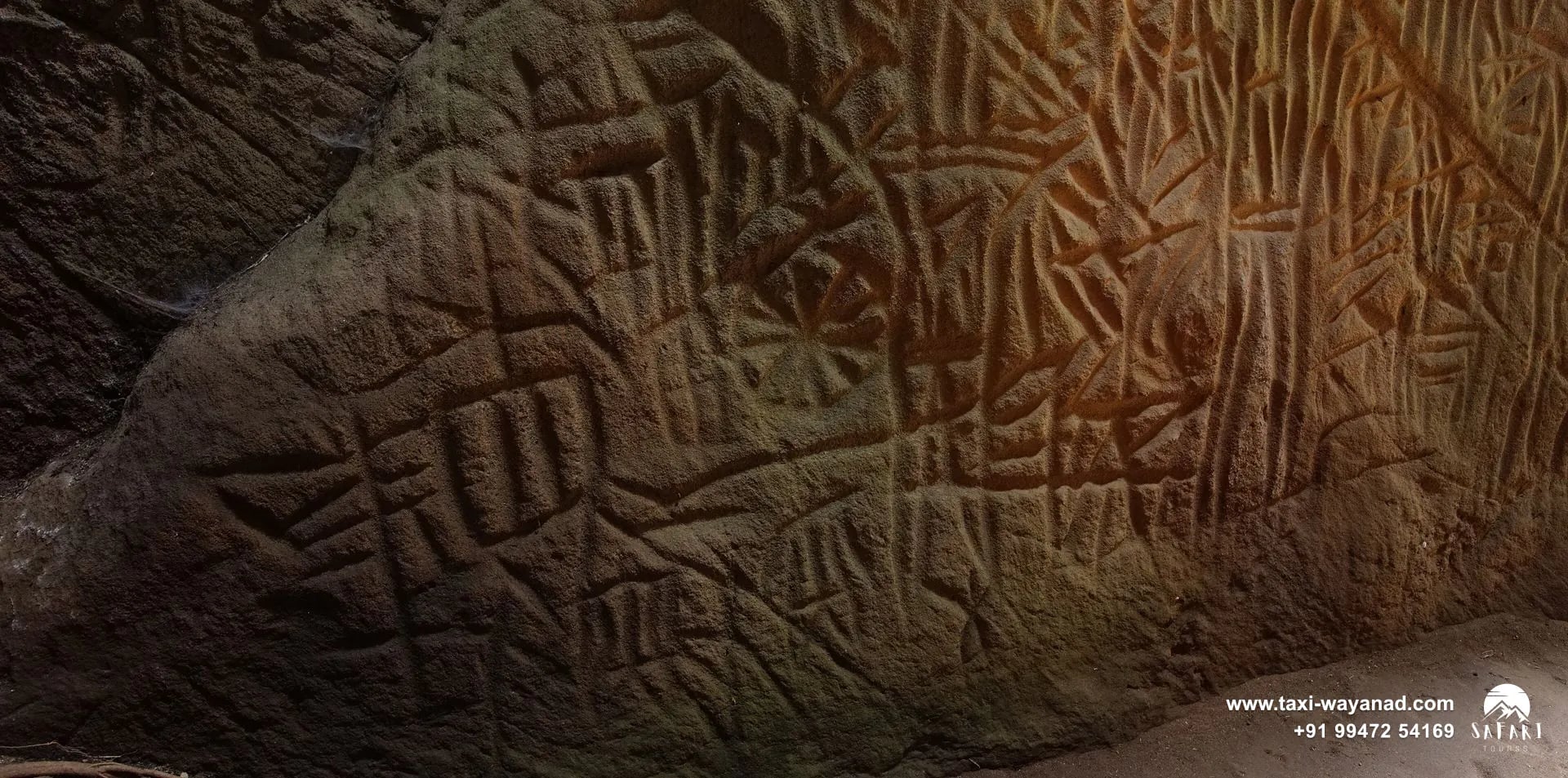 Rock wall covered in ancient carvings inside Edakkal Caves, Wayanad