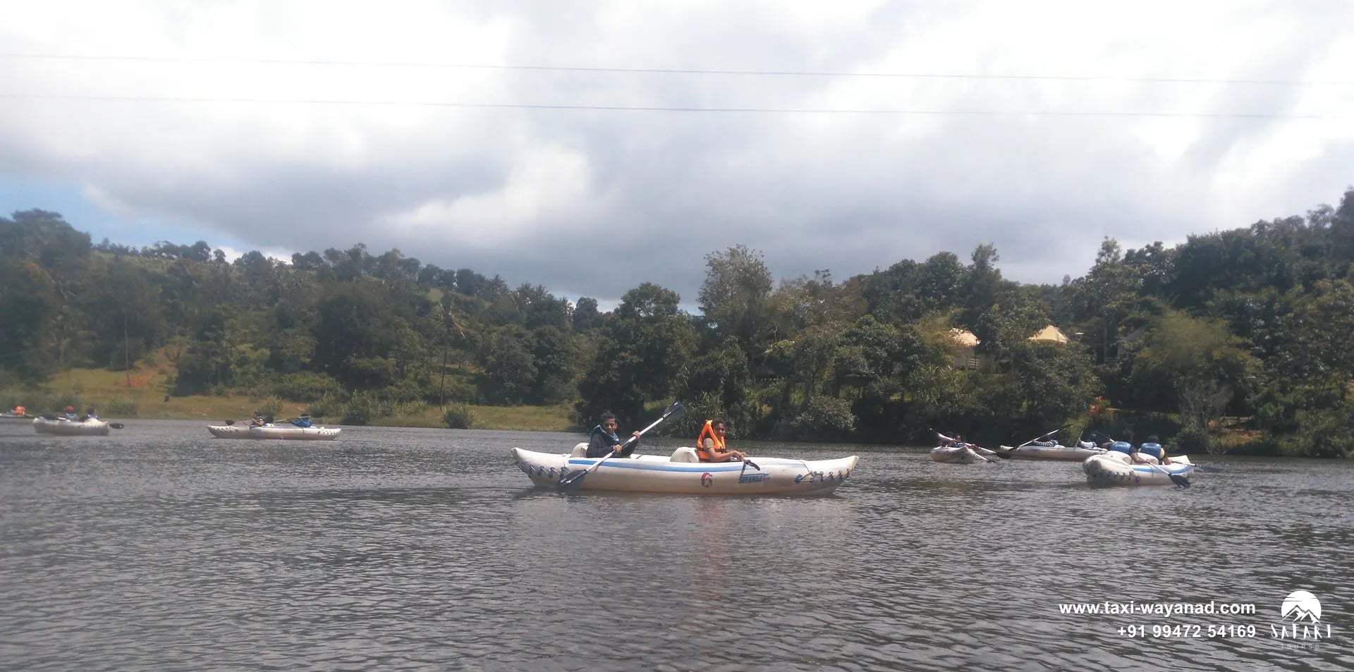 Visitors kayaking on Karlad Lake beneath a cloudy sky, Wayanad