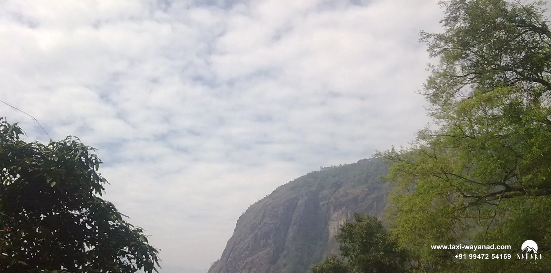 Forested valley and rocky cliff face beside Meenmutty Waterfalls, Wayanad