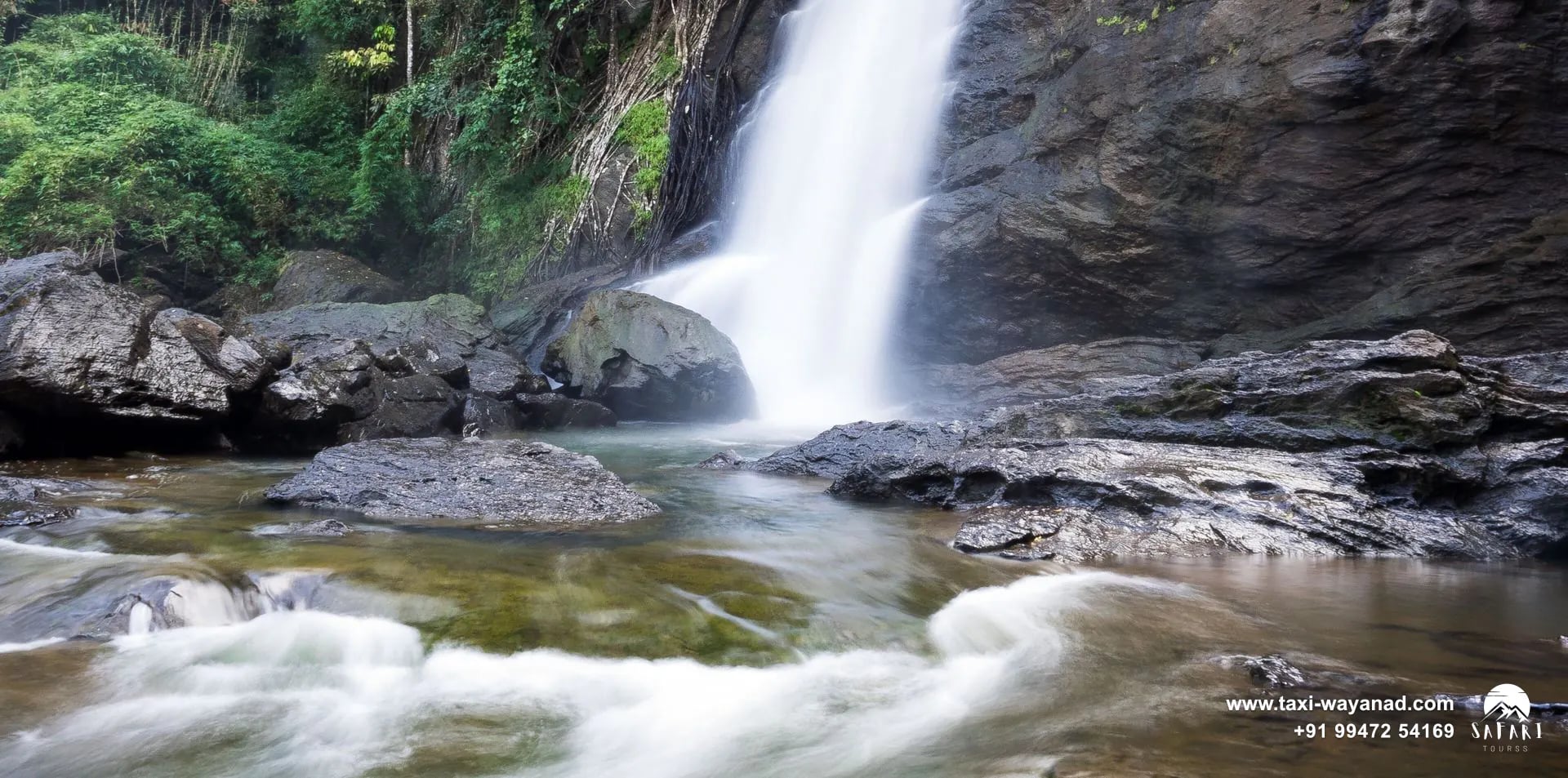 Soochipara Waterfalls dropping beside a sheer rock wall into a rocky pool, Wayanad