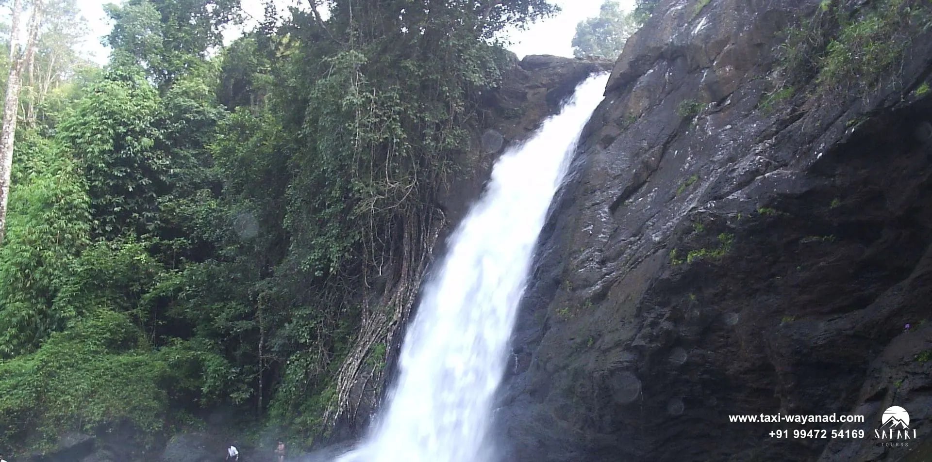 Visitors standing in the natural pool at the foot of Soochipara Waterfalls, Wayanad