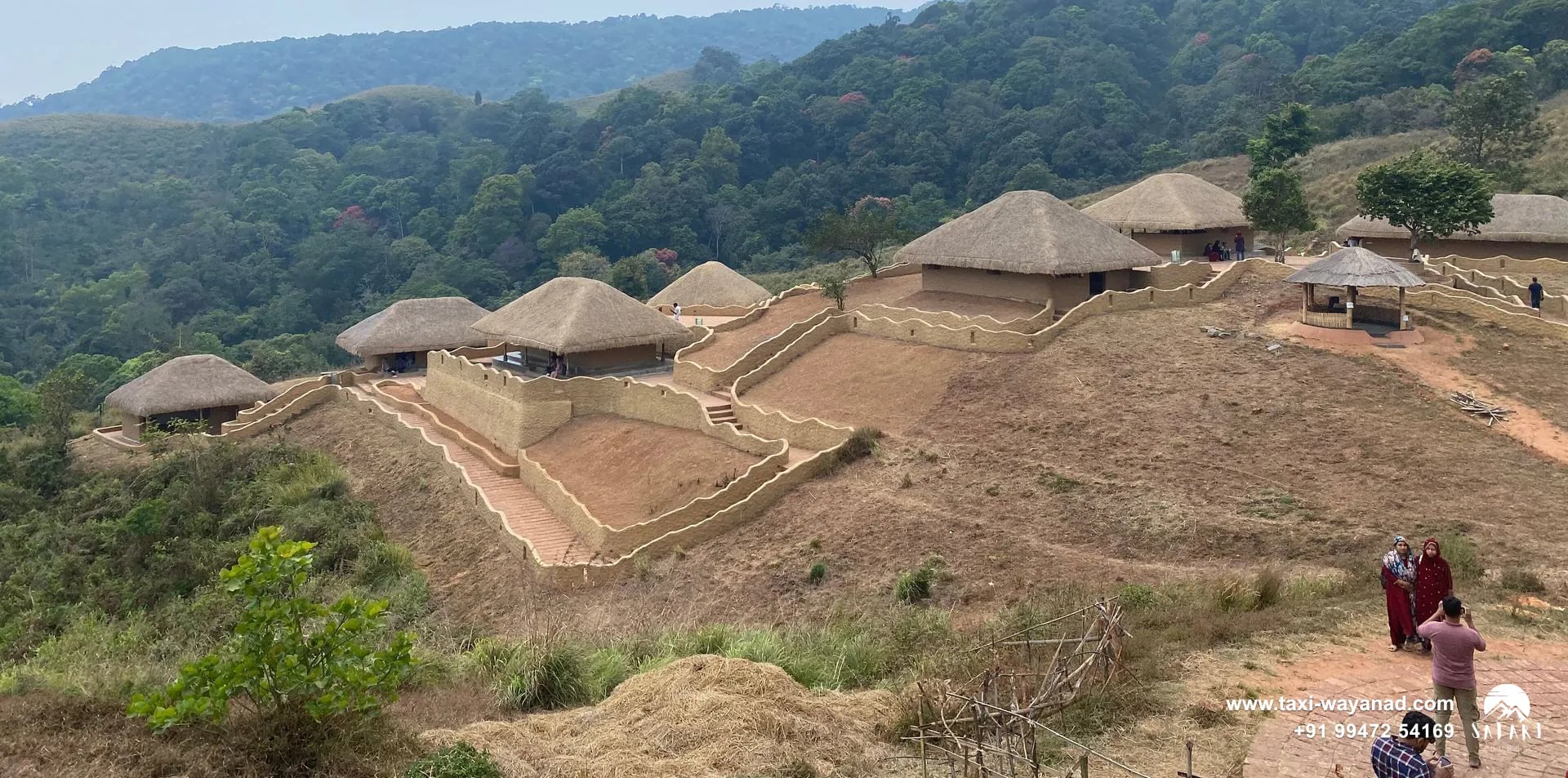 Cluster of thatched huts and walled paths spread over the slope at En Ooru tribal village, Wayanad