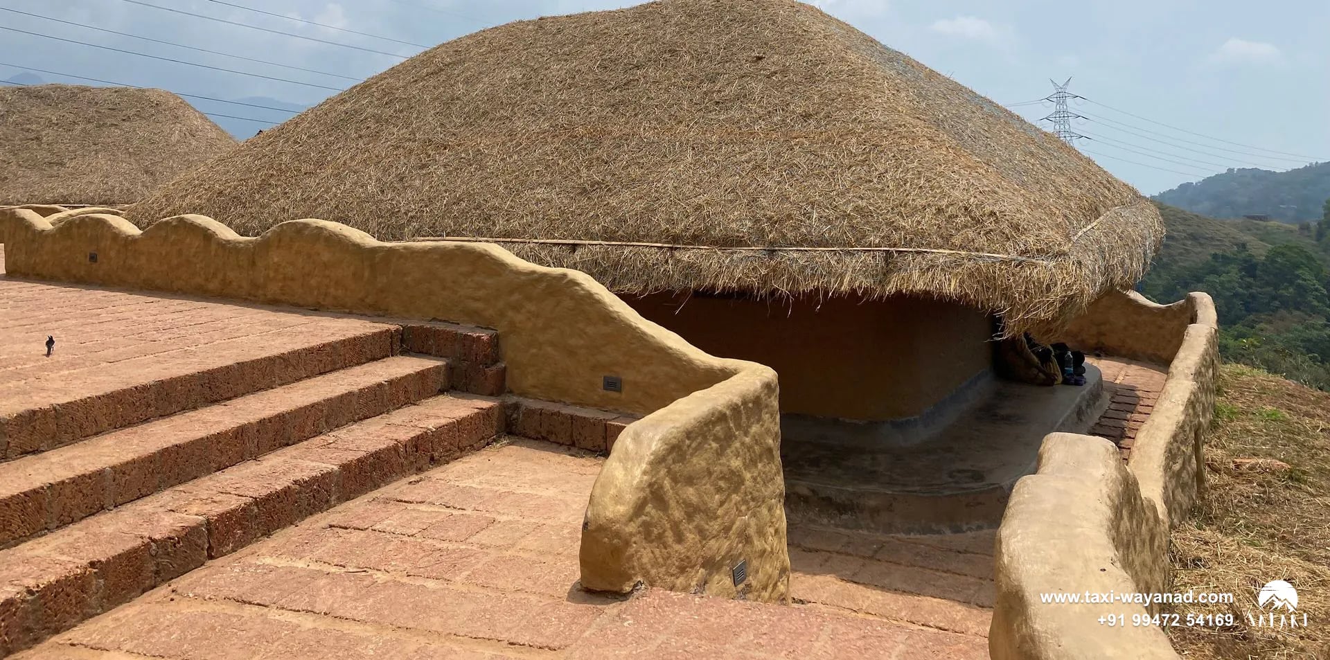 Curved mud walls and steps leading to a thatched hut at En Ooru tribal village, Wayanad